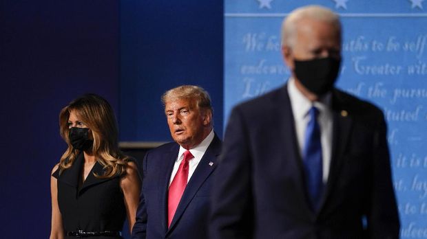 first lady Melania Trump, left, and President Donald Trump, center, remain on stage as Democratic presidential candidate former Vice President Joe Biden, right, walk away at the conclusion of the second and final presidential debate Thursday, Oct. 22, 2020, at Belmont University in Nashville, Tenn. (AP Photo/Julio Cortez)