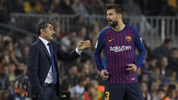 Barcelonas Spanish coach Ernesto Valverde (L) speaks to Barcelonas Spanish defender Gerard Pique during the Spanish league football match FC Barcelona against Sevilla FC at the Camp Nou stadium in Barcelona on October 20, 2018. (Photo by LLUIS GENE / AFP)