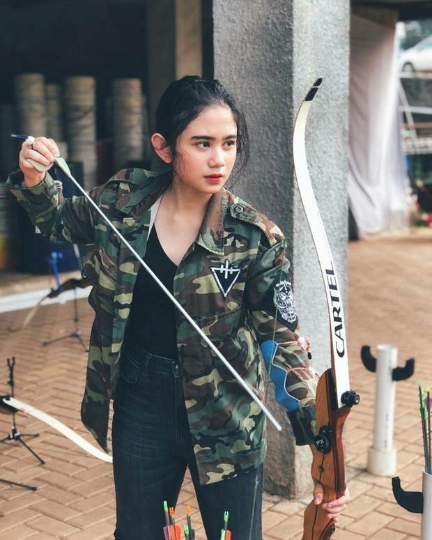 B Sambil memegang busur panah, Tissa berpose candid dengan ancang-ancang segera melayangkan busurnya tersebut ke arah sasaran.