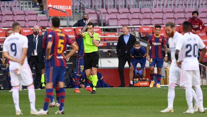 BARCELONA, SPAIN - OCTOBER 24: Referee Juan Martinez Munuera awards Real Madrid a penalty following a VAR review during the La Liga Santander match between FC Barcelona and Real Madrid at Camp Nou on October 24, 2020 in Barcelona, Spain. Sporting stadiums around Spain remain under strict restrictions due to the Coronavirus Pandemic as Government social distancing laws prohibit fans inside venues resulting in games being played behind closed doors. (Photo by Alex Caparros/Getty Images)