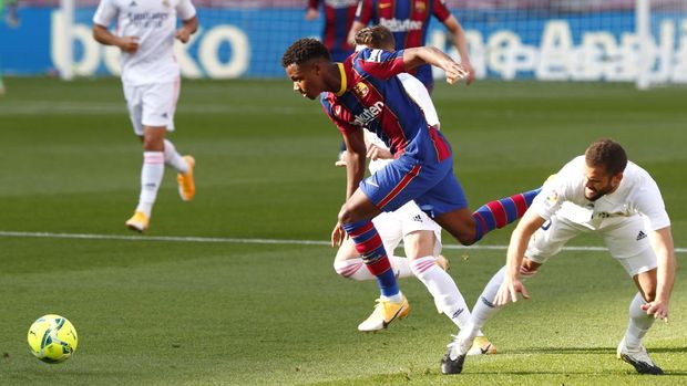 Barcelona's Ansu Fati fights for the ball against Real Madrid's Nacho during the Spanish La Liga soccer match between FC Barcelona and Real Madrid at the Camp Nou stadium in Barcelona, Spain, Saturday, Oct. 24, 2020. (AP Photo/Joan Monfort)