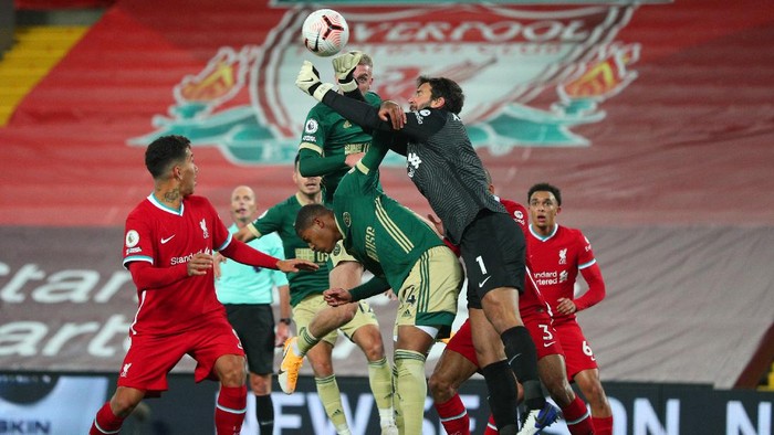 LIVERPOOL, ENGLAND - OCTOBER 24: Alisson Becker of Liverpool clears the ball under pressure from Oli McBurnie of Sheffield United during the Premier League match between Liverpool and Sheffield United at Anfield on October 24, 2020 in Liverpool, England. Sporting stadiums around the UK remain under strict restrictions due to the Coronavirus Pandemic as Government social distancing laws prohibit fans inside venues resulting in games being played behind closed doors. (Photo by Peter Byrne - Pool/Getty Images)