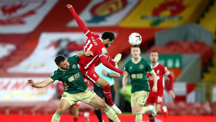 LIVERPOOL, ENGLAND - OCTOBER 24: Enda Stevens of Sheffield United battles for possession with Mohamed Salah of Liverpool during the Premier League match between Liverpool and Sheffield United at Anfield on October 24, 2020 in Liverpool, England. Sporting stadiums around the UK remain under strict restrictions due to the Coronavirus Pandemic as Government social distancing laws prohibit fans inside venues resulting in games being played behind closed doors. (Photo by Michael Steele/Getty Images)