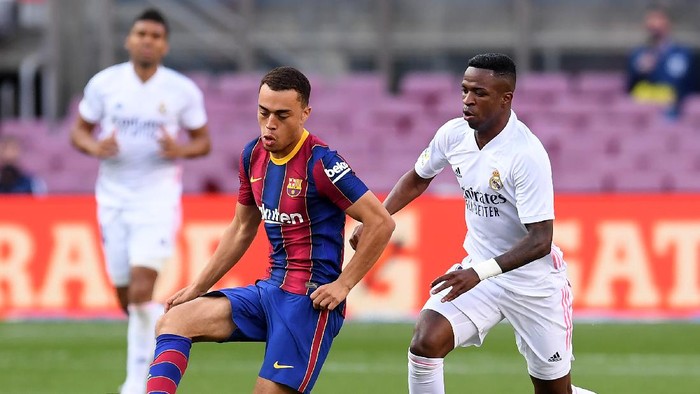 BARCELONA, SPAIN - OCTOBER 24: Sergino Dest of Barcelona  battles for possession with  Vinicius Junior of Real Madrid  during the La Liga Santander match between FC Barcelona and Real Madrid at Camp Nou on October 24, 2020 in Barcelona, Spain. Sporting stadiums around Spain remain under strict restrictions due to the Coronavirus Pandemic as Government social distancing laws prohibit fans inside venues resulting in games being played behind closed doors. (Photo by Alex Caparros/Getty Images)