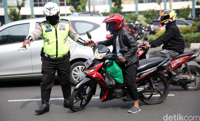 Operasi Zebra di Cawang Anggota Polisi Satua Lalu Lintas Polres Jakarta Timur melakukan razia kendaraan bermotor di Jalan DI Panjaitan, Cawang, Jakarta Timur, Senin (26/10/2020). Operasi Zebra 2020 mulai digelar Senin (26/10). Ada lima jenis pelanggaran yang menjadi prioritas sasaran penindakan dalam operasi yang mau berjalan hingga 8 November mendatang.