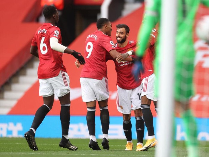 MANCHESTER, ENGLAND - OCTOBER 04: Bruno Fernandes of Manchester United celebrates with teammates after scoring his sides first goal  during the Premier League match between Manchester United and Tottenham Hotspur at Old Trafford on October 04, 2020 in Manchester, England. Sporting stadiums around the UK remain under strict restrictions due to the Coronavirus Pandemic as Government social distancing laws prohibit fans inside venues resulting in games being played behind closed doors. (Photo by Carl Recine - Pool/Getty Images)