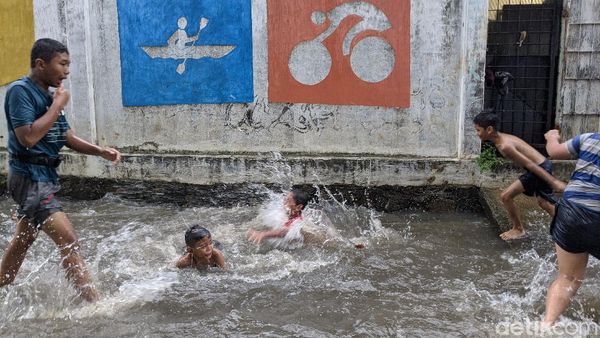 Genangan Air Jadi Hiburan Anak-Anak Petogogan