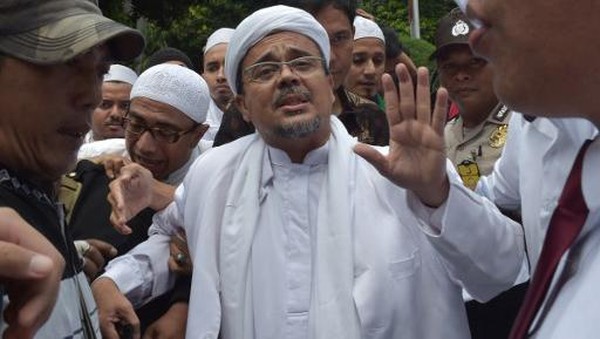 Rizieq Shihab, leader of the Indonesian hardline Muslim group FPI (Front Pembela Islam or Islamic Defender Front), arrives at the police headquarters in Jakarta on January 23, 2017. - Shihab was summoned as a witness by police over allegations he insulted rupiah bank notes by saying they contained communist symbols. (Photo by ADEK BERRY / AFP)