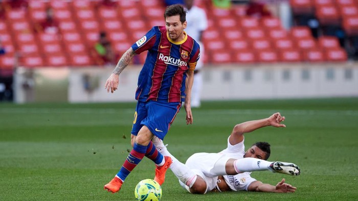 BARCELONA, SPAIN - OCTOBER 24: Carlos Casemiro of Real Madrid CF tackles Lionel Messi of FC Barcelona during the La Liga Santander match between FC Barcelona and Real Madrid at Camp Nou on October 24, 2020 in Barcelona, Spain. Sporting stadiums around Spain remain under strict restrictions due to the Coronavirus Pandemic as Government social distancing laws prohibit fans inside venues resulting in games being played behind closed doors. (Photo by Alex Caparros/Getty Images)