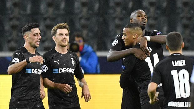 Moenchengladbach's Marcus Thuram, center, celebrates with his teammate Moenchengladbach's Alassane Plea after scoring his side's opening goal during the Champions League group B soccer match between Borussia Moenchengladbach and Real Madrid at the Borussia Park in Moenchengladbach, Germany, Tuesday, Oct. 27, 2020. (AP Photo/Martin Meissner)