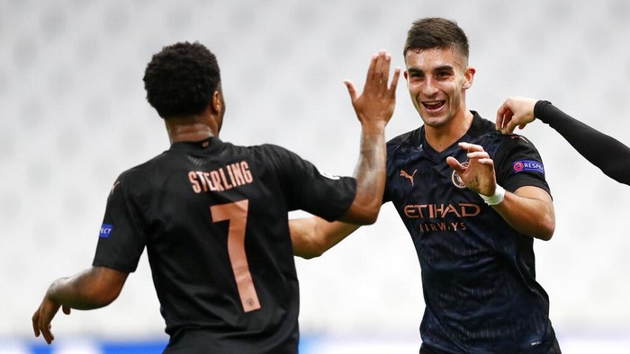 Manchester Citys Ferran Torres, right, is congratulated by teammate Raheem Sterling, left, after scoring his teams first goal during the Champions League Group C soccer match between Marseille and Manchester City at Stade Velodrome in Marseille, France, Tuesday, Oct. 27, 2020. (Guillaume Horcajuelo/Pool via AP)
