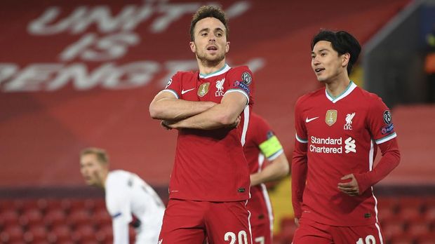 Liverpool's Diogo Jota, 20, celebrates scoring his side's first goal with Liverpool's Takumi Minamino, right, during the Champions League Group D soccer match between Liverpool and FC Midtjylland at Anfield stadium, in Liverpool, England, Tuesday, Oct. 27, 2020. (Michael Regan/Pool via AP)