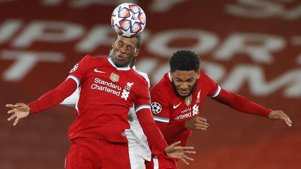 Liverpool's Georginio Wijnaldum heads the ball as he jumps with teammate Liverpool's Joe Gomez during the Champions League Group D soccer match between Liverpool and FC Midtjylland at Anfield stadium, in Liverpool, England, Tuesday, Oct. 27, 2020. (Phil Noble/Pool via AP)