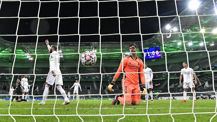 Real Madrids goalkeeper Thibaut Courtois watches the ball in his net after Moenchengladbachs Marcus Thuram scored the second goal during the Champions League group B soccer match between Borussia Moenchengladbach and Real Madrid at the Borussia Park in Moenchengladbach, Germany, Tuesday, Oct. 27, 2020. (AP Photo/Martin Meissner)