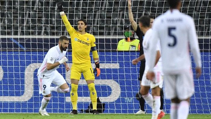 Real Madrids Karim Benzema, left, celebrates after scoring his sides opening goal during the Champions League group B soccer match between Borussia Moenchengladbach and Real Madrid at the Borussia Park in Moenchengladbach, Germany, Tuesday, Oct. 27, 2020. (AP Photo/Martin Meissner)