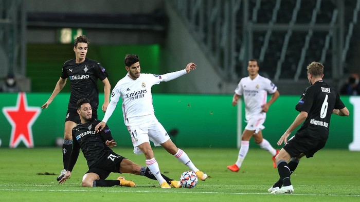 MOENCHENGLADBACH, GERMANY - OCTOBER 27: Marco Asensio of Real Madrid is challenged by Ramy Bensebaini of Borussia Moenchengladbach during the UEFA Champions League Group B stage match between Borussia Moenchengladbach and Real Madrid at Borussia-Park on October 27, 2020 in Moenchengladbach, Germany. Football Stadiums around Europe remain empty due to the Coronavirus Pandemic as Government social distancing laws prohibit fans inside venues resulting in fixtures being played behind closed doors. (Photo by Lars Baron/Getty Images)