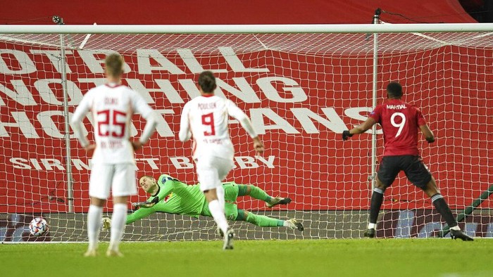 Leipzigs goalkeeper Peter Gulacsi fails to save the ball as Manchester Uniteds Anthony Martial, right, scores his sides fourth goal from the penalty spot during the Champions League group H soccer match between Manchester United and RB Leipzig, at the Old Trafford stadium in Manchester, England, Wednesday, Oct. 28, 2020. (AP Photo/Dave Thompson)