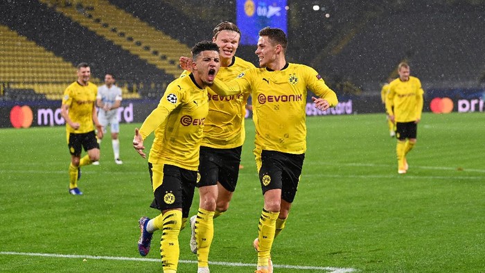 DORTMUND, GERMANY - OCTOBER 28: Jadon Sancho of Borussia Dortmund celebrates with teammates Thorgan Hazard and Erling Haaland  after scoring his teams first goal from the penalty spot during the UEFA Champions League Group F stage match between Borussia Dortmund and Zenit St. Petersburg at Signal Iduna Park on October 28, 2020 in Dortmund, Germany. Sporting stadiums around Dortmund remain under strict restrictions due to the Coronavirus Pandemic as Government social distancing laws prohibit fans inside venues resulting in games being played behind closed doors. (Photo by Lukas Schulze/Getty Images)