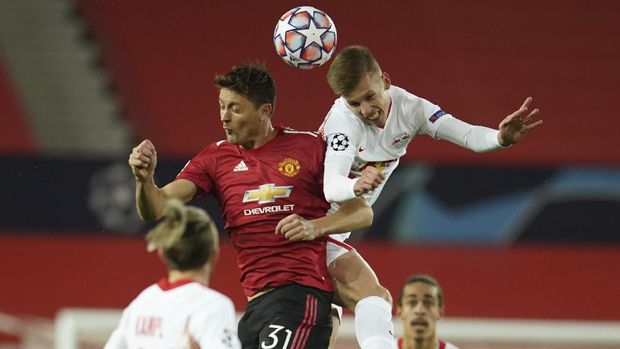 Manchester United's Nemanja Matic, left, jumps for the ball with Leipzig's Daniel Olmo during the Champions League group H soccer match between Manchester United and RB Leipzig, at the Old Trafford stadium in Manchester, England, Wednesday, Oct. 28, 2020. (AP Photo/Dave Thompson)