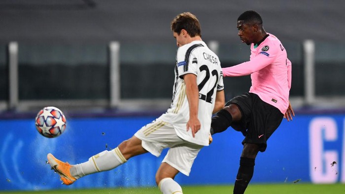 TURIN, ITALY - OCTOBER 28: Ousmane Dembele of Barcelona scores his sides first goal whilst under pressure from Federico Chiesa of Juventus during the UEFA Champions League Group G stage match between Juventus and FC Barcelona at Juventus Stadium on October 28, 2020 in Turin, Italy. Sporting stadiums around Italy remain under strict restrictions due to the Coronavirus Pandemic as Government social distancing laws prohibit fans inside venues resulting in games being played behind closed doors. (Photo by Valerio Pennicino/Getty Images)