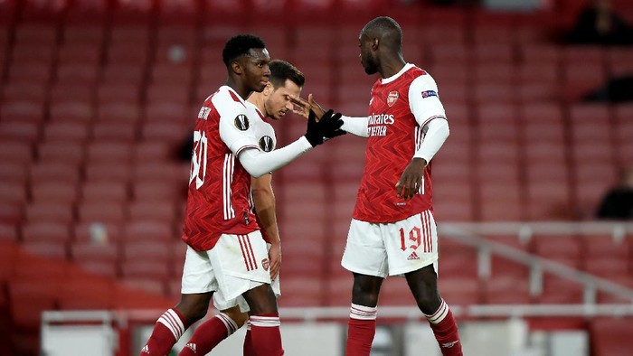 LONDON, ENGLAND - OCTOBER 29: Eddie Nketiah of Arsenal celebrates with teammate Cedric Soares and Nicolas Pepe of Arsenal after scoring his teams first goal during the UEFA Europa League Group B stage match between Arsenal FC and Dundalk FC at Emirates Stadium on October 29, 2020 in London, England. Sporting stadiums around the UK remain under strict restrictions due to the Coronavirus Pandemic as Government social distancing laws prohibit fans inside venues resulting in games being played behind closed doors. (Photo by Mike Hewitt/Getty Images)