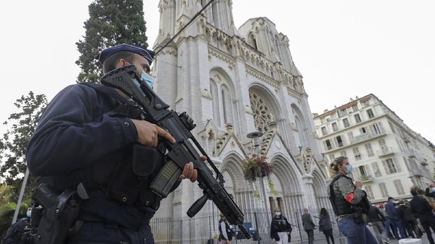 A French police officers stands near Notre Dame church in Nice, southern France, Thursday, Oct. 29, 2020. French President Emmanuel Macron has announced that he will more than double number of soldiers deployed to protect against attacks to 7,000 after three people were killed at a church Thursday. (Eric Gaillard/Pool via AP)