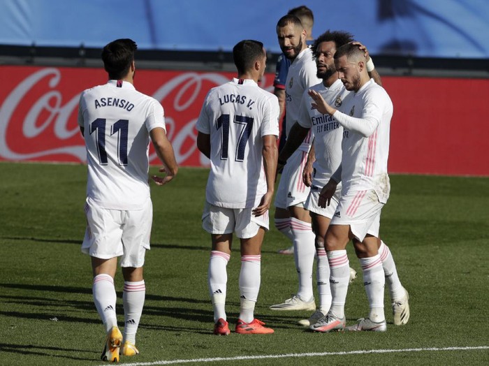 Real Madrids Eden Hazard, right, celebrates with teammates after scoring the opening goal during the Spanish La Liga soccer match between Real Madrid and Huesca at Alfredo di Stefano stadium in Madrid, Spain, Saturday, Oct. 31, 2020. (AP Photo/Manu Fernandez)