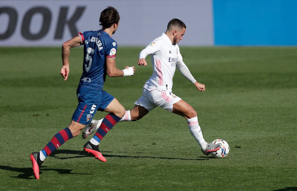 MADRID, SPAIN - OCTOBER 31: Eden Hazard of Real Madrid is challenged by Borja Garcia of SD Huesca during the La Liga Santander match between Real Madrid and SD Huesca at Estadio Santiago Bernabeu on October 31, 2020 in Madrid, Spain. Sporting stadiums around Spain remain under strict restrictions due to the Coronavirus Pandemic as Government social distancing laws prohibit fans inside venues resulting in games being played behind closed doors. (Photo by Gonzalo Arroyo Moreno/Getty Images)
