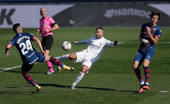 MADRID, SPAIN - OCTOBER 31: Eden Hazard of Real Madrid is challenged by Borja Garcia of SD Huesca during the La Liga Santander match between Real Madrid and SD Huesca at Estadio Santiago Bernabeu on October 31, 2020 in Madrid, Spain. Sporting stadiums around Spain remain under strict restrictions due to the Coronavirus Pandemic as Government social distancing laws prohibit fans inside venues resulting in games being played behind closed doors. (Photo by Gonzalo Arroyo Moreno/Getty Images)