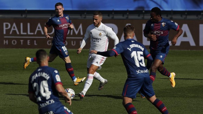 Real Madrids Eden Hazard, center, runs with the ball next to Huesca defenders during the Spanish La Liga soccer match between Real Madrid and Huesca at Alfredo di Stefano stadium in Madrid, Spain, Saturday, Oct. 31, 2020. (AP Photo/Manu Fernandez)