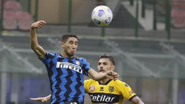 Inter Milan's Achraf Hakimi, left, jumps for the ball with Parma's Giuseppe Pezzella during the Serie A soccer match between Inter Milan and Parma at the San Siro Stadium, in Milan, Italy, Saturday, Oct. 31, 2020. (AP Photo/Antonio Calanni)