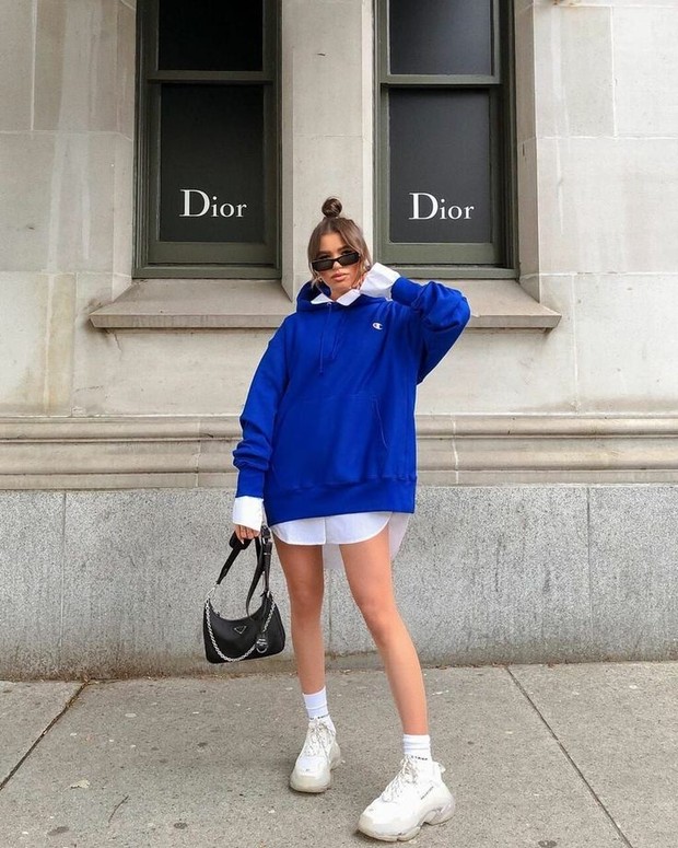 Lapisi oversized button-down shirt dengan oversized sweater yang ada di lemari pakaian kamu.