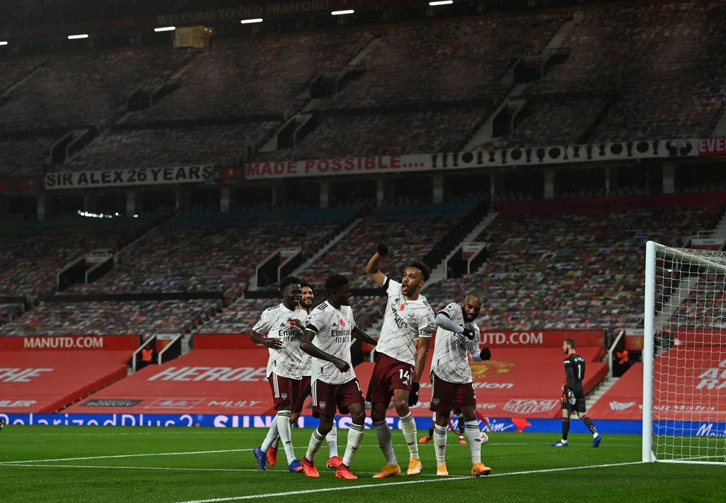 MANCHESTER, ENGLAND - NOVEMBER 01: Pierre-Emerick Aubameyang of Arsenal celebrates with teammates after scoring his sides first goal  during the Premier League match between Manchester United and Arsenal at Old Trafford on November 01, 2020 in Manchester, England. Sporting stadiums around the UK remain under strict restrictions due to the Coronavirus Pandemic as Government social distancing laws prohibit fans inside venues resulting in games being played behind closed doors. (Photo by Paul Ellis - Pool/Getty Images)