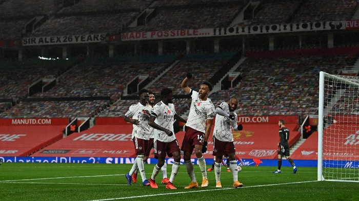 MANCHESTER, ENGLAND - NOVEMBER 01: Pierre-Emerick Aubameyang of Arsenal celebrates with teammates after scoring his sides first goal  during the Premier League match between Manchester United and Arsenal at Old Trafford on November 01, 2020 in Manchester, England. Sporting stadiums around the UK remain under strict restrictions due to the Coronavirus Pandemic as Government social distancing laws prohibit fans inside venues resulting in games being played behind closed doors. (Photo by Paul Ellis - Pool/Getty Images)