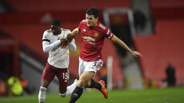 Manchester United's Harry Maguire, right, fights for the ball with Arsenal's Ainsley Maitland-Niles during the English Premier League soccer match between Manchester United and Arsenal at the Old Trafford stadium in Manchester, England, Sunday, Nov. 1, 2020. (Paul Ellis/Pool via AP)