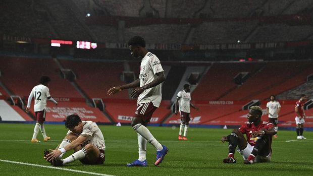 Manchester United's Paul Pogba, right, fouls Arsenal's Hector Bellerin for a penalty during the English Premier League soccer match between Manchester United and Arsenal at the Old Trafford stadium in Manchester, England, Sunday, Nov. 1, 2020. (Paul Ellis/Pool via AP)