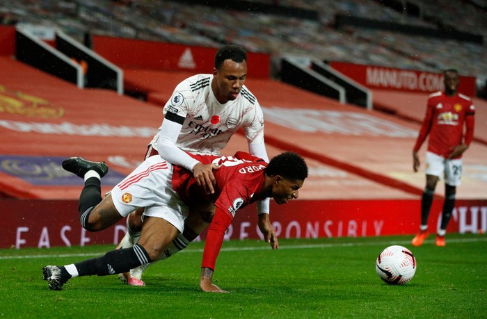 MANCHESTER, ENGLAND - NOVEMBER 01: Marcus Rashford of Manchester United is challenged by Gabriel of Arsenal during the Premier League match between Manchester United and Arsenal at Old Trafford on November 01, 2020 in Manchester, England. Sporting stadiums around the UK remain under strict restrictions due to the Coronavirus Pandemic as Government social distancing laws prohibit fans inside venues resulting in games being played behind closed doors. (Photo by Phil Noble - Pool/Getty Images)