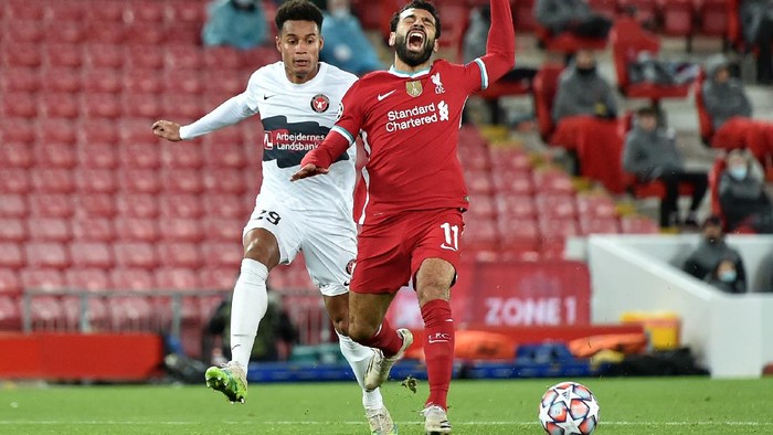 LIVERPOOL, ENGLAND - OCTOBER 27: Mohamed Salah of Liverpool is fouled by Paulinho of FC Midtjylland which leads to a penalty being awarded  during the UEFA Champions League Group D stage match between Liverpool FC and FC Midtjylland at Anfield on October 27, 2020 in Liverpool, England. Sporting stadiums around the UK remain under strict restrictions due to the Coronavirus Pandemic as Government social distancing laws prohibit fans inside venues resulting in games being played behind closed doors. (Photo by Peter Powell -