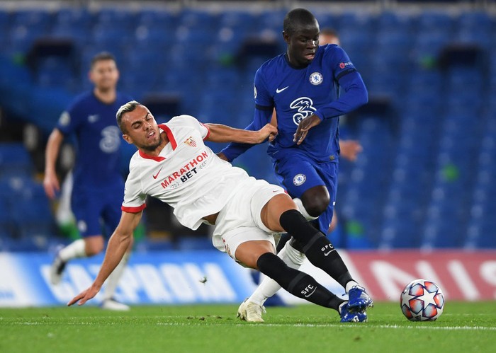 LONDON, ENGLAND - OCTOBER 20: NGolo Kante of Chelsea is challenged by Joan Jordan of FC Sevilla during the UEFA Champions League Group E stage match between Chelsea FC and FC Sevilla at Stamford Bridge on October 20, 2020 in London, England. Sporting stadiums around the UK remain under strict restrictions due to the Coronavirus Pandemic as Government social distancing laws prohibit fans inside venues resulting in games being played behind closed doors. (Photo by Mike Hewitt/Getty Images)