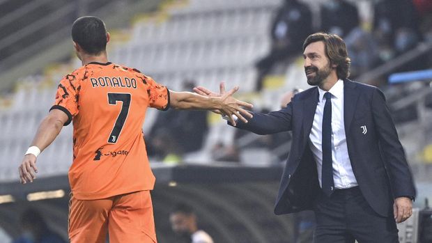 Juventus' Cristiano Ronaldo, left, is congratulated by coach Andrea Pirlo after scoring his side's fourth goal, during the Serie A soccer match between Spezia and Juventus, at the Dino Manuzzi Stadium in Cesena, Italy, Sunday, Nov. 1, 2020. (Massimo Paolone/LaPresse via AP)