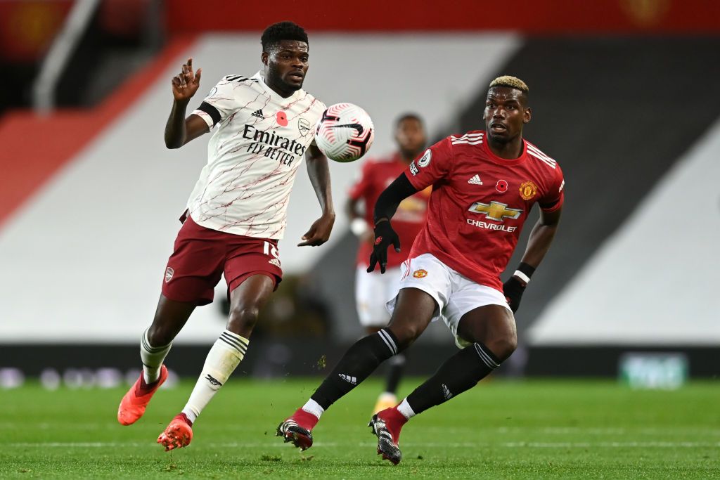 MANCHESTER, ENGLAND - NOVEMBER 01: Thomas Partey of Arsenal is put under pressure by Paul Pogba of Manchester United during the Premier League match between Manchester United and Arsenal at Old Trafford on November 01, 2020 in Manchester, England. Sporting stadiums around the UK remain under strict restrictions due to the Coronavirus Pandemic as Government social distancing laws prohibit fans inside venues resulting in games being played behind closed doors. (Photo by Shaun Botterill/Getty Images)