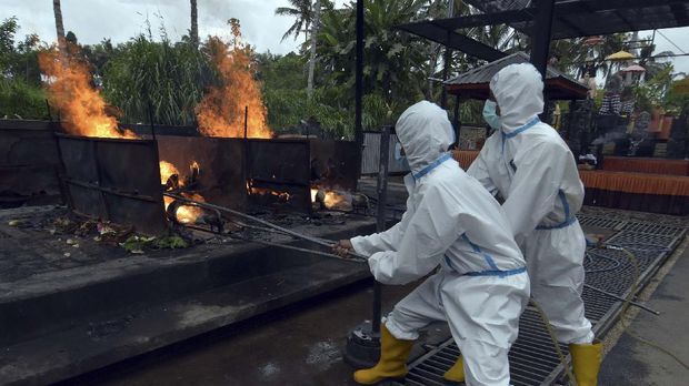 Adat dan Budaya Bali di Masa Pandemi Petugas menggunakan alat pelindung diri saat prosesi Ngaben bagi jenazah korban COVID-19 di Krematorium Sagraha Mandra Kantha Santhi, Desa Bebalang, Bangli.