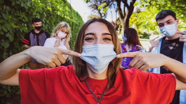 ilustrasi senyum pakai masker Group of teenagers posing showing their protective face masks during Covid-19 Coronavirus epidemic spread.