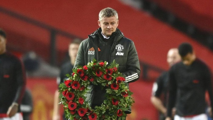 Manchester Uniteds manager Ole Gunnar Solskjaer carries out a wreath before kick-off in the English Premier League soccer match between Manchester United and Arsenal at the Old Trafford stadium in Manchester, England, Sunday, Nov. 1, 2020. (Shaun Botterill/Pool via AP)