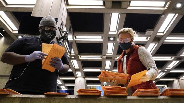 Election officials sort absentee and early voting ballots for counting inside Boston City Hall, Monday, Nov. 2, 2020, in Boston. (AP Photo/Elise Amendola)