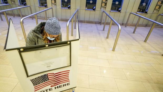 A voter marks her ballot during the first hour of voting in New York at Madison Square Garden, Tuesday, Nov. 3, 2020. (AP Photo/Mary Altaffer)