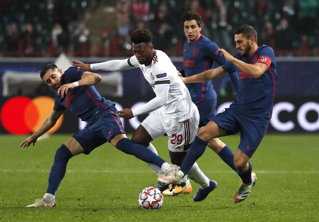 Atletico Madrid's Hector Herrera, left, Atletico Madrid's Koke, right, and Lokomotiv Moscow's Ze Luis challenge for the ball during the Champions League Group A soccer match between Lokomotiv Moscow and Atletico Madrid in Moscow, Russia, Tuesday, Nov. 3, 2020. (Yuri Kochetkov/Pool via AP)