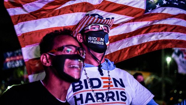 Alex Suarez (L) and Ralph Reichard (R) supporters of the Democratic party cheer as they attend a watch party in Miami, Florida on November 3, 2020. - The US is voting Tuesday in an election amounting to a referendum on Donald Trump's uniquely brash and bruising presidency, which Democratic opponent and frontrunner Joe Biden urged Americans to end to restore 