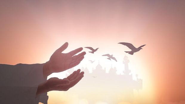 Silhouette muslim dua to Allah over mosque sunset background