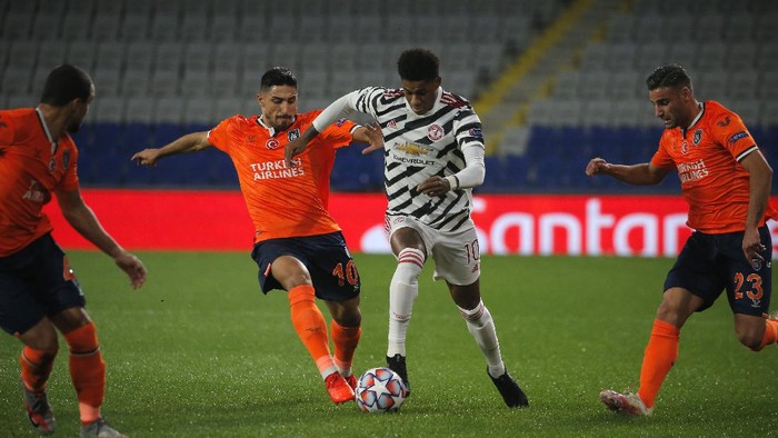 Manchester Uniteds Marcus Rashford, second right, is challenged by Basaksehirs Berkay Ozcan, second left, Basaksehirs Aziz Behich, right, and Basaksehirs Rafael during the Champions League group H soccer match between Istanbul Basaksehir and Manchester United at the Fatih Terim stadium in Istanbul, Wednesday, Nov. 4, 2020. (AP Photo)